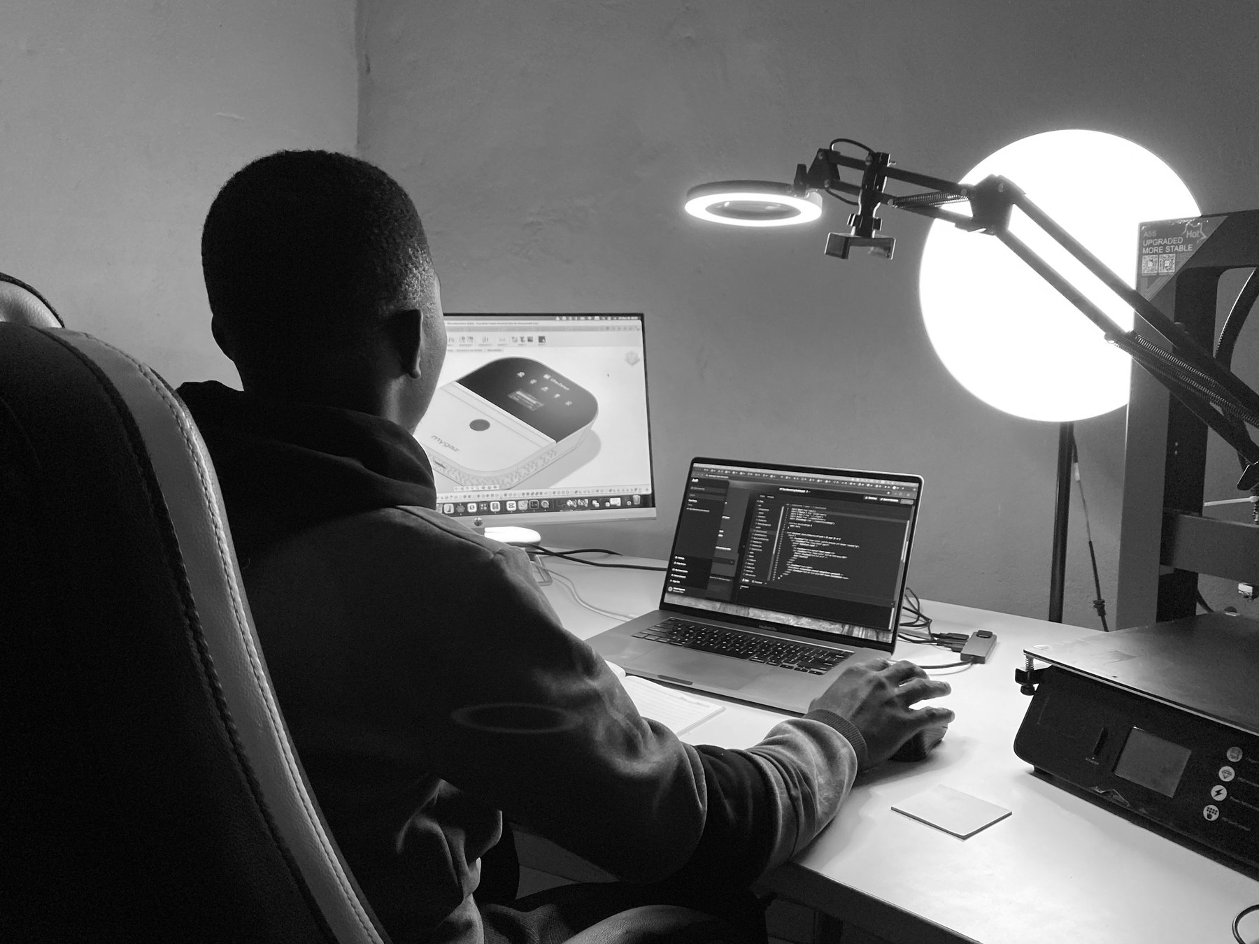 Ruben at the workstation: MYGAZ V4 in Fusion 360 on the monitor, firmware on the laptop, 3D printer to the right